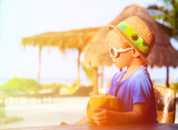 μικρό αγόρι πόσιμο καρύδας κοκτέιλ στην παραλία - Φωτογραφία, εικόνα