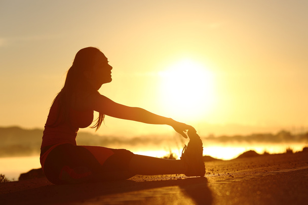 Sziluettjét egy fitness nő, nyúlik a naplemente - Fotó, kép