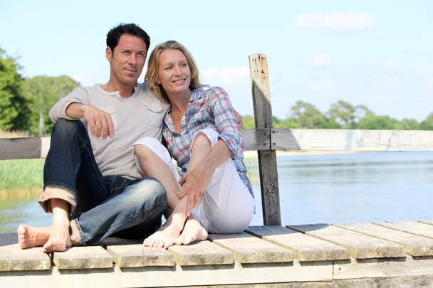 Couple sat on jetty - Foto, Bild