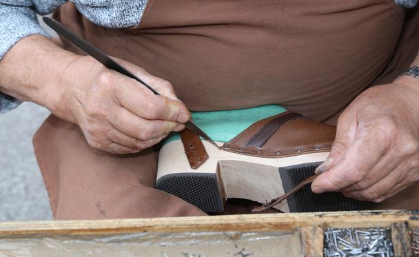 handen van oude schoenmakersambacht in de werkplaats - Foto, afbeelding