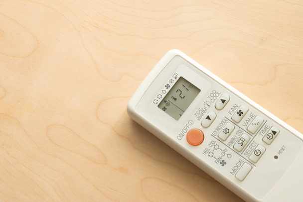 Air conditioner remote control on wood floor. - Foto, imagen