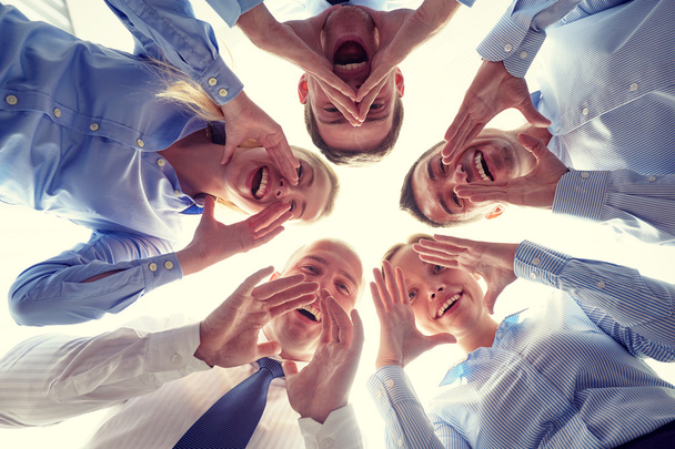 smiling group of businesspeople standing in circle - Fotó, kép