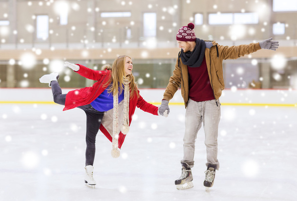 happy couple holding hands on skating rink - Foto, afbeelding