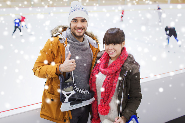 happy couple with ice-skates on skating rink - Fotografie, Obrázek