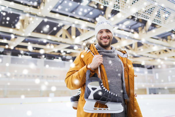 happy young man with ice-skates on skating rink - Valokuva, kuva