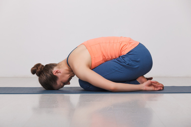 Hermosa chica yogui en forma deportiva practica yoga asana balasana
 - Foto, imagen