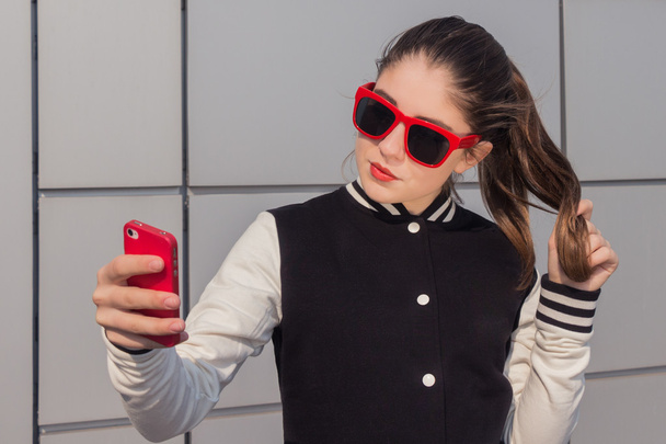 Menina adolescente elegante tomando auto retrato com telefone celular
 - Foto, Imagem