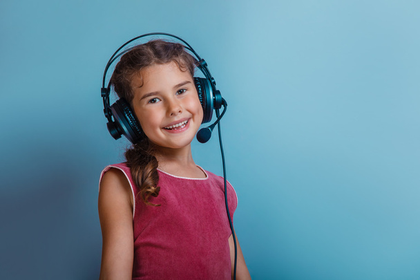 Девочка европейского появления десятилетие слушать музыку с headph
 - Фото, изображение