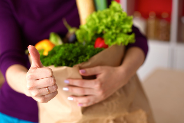 Santé positive femme heureuse tenant un sac à provisions en papier plein de fruits et légumes
 - Photo, image