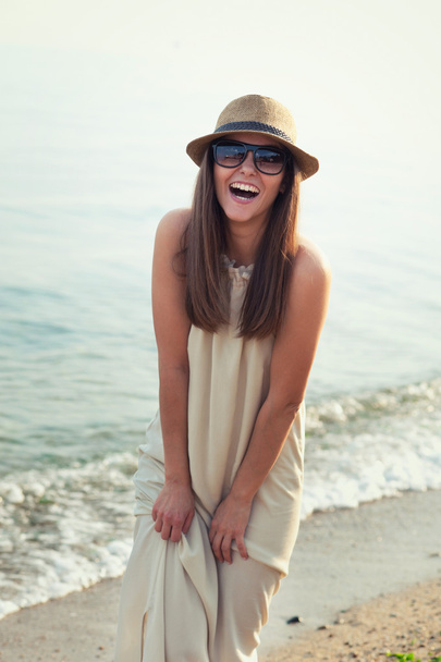 Χαμογελώντας hipster κορίτσι περπάτημα σε μια παραλία στη θάλασσα. - Φωτογραφία, εικόνα