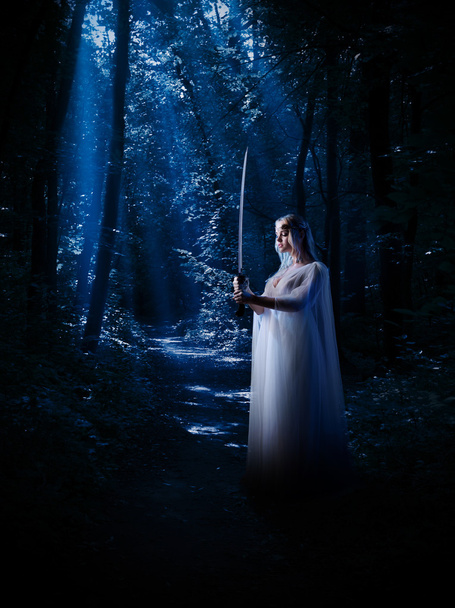 Elven girl with sword at night forest - Fotoğraf, Görsel