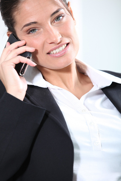 Smiling female executive on cellphone - 写真・画像
