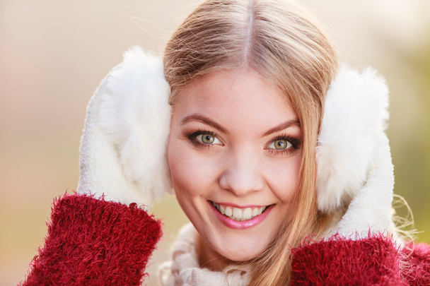 Portrait of pretty smiling woman in white earmuffs. - Fotografie, Obrázek