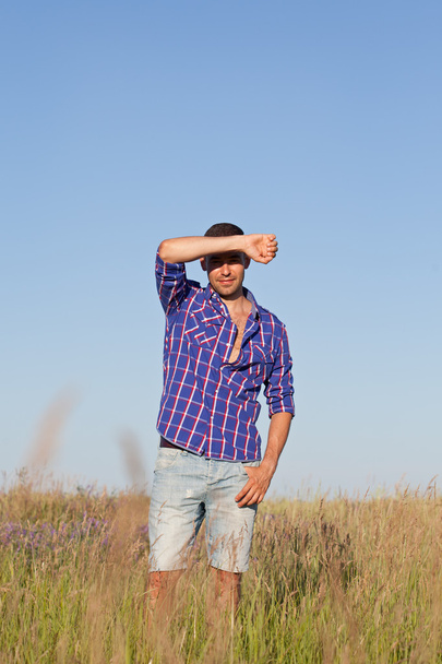 Attractive young man standing in a field - 写真・画像