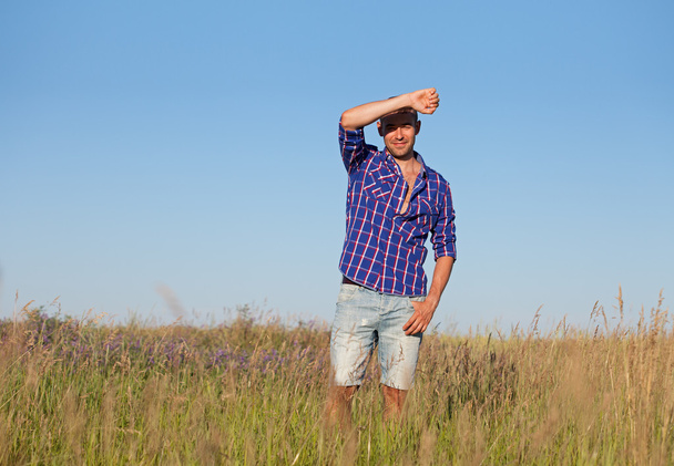 Jeune homme attrayant debout dans un champ
 - Photo, image
