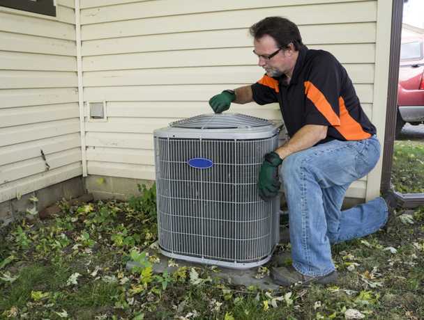 Repirman zieht Lüfterblende an Klimaanlage an - Foto, Bild