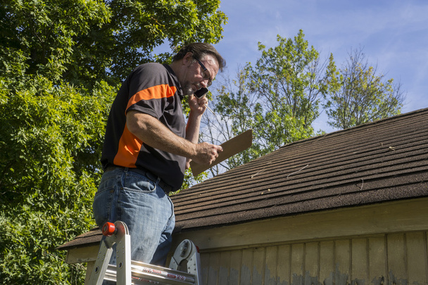 Contractor On Ladder Figuring Hail Damage Repairs To Roof - Photo, Image