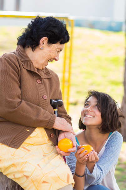 Grand-mère petite-fille temps de qualité en plein air tenant une orange
 - Photo, image