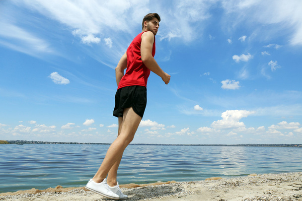 Young man jogging on beach - Foto, immagini