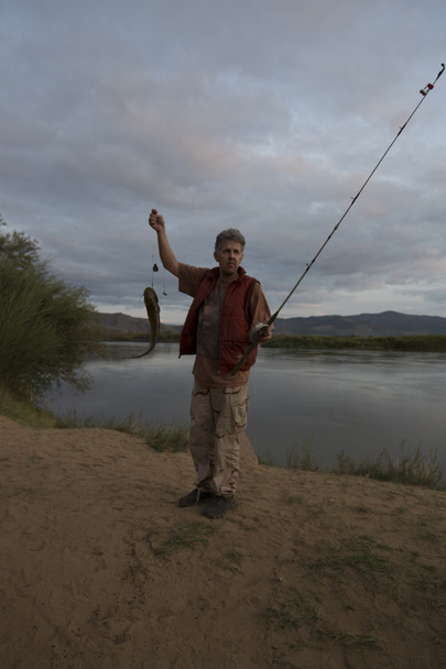 Kalastaja, joka tuuppii kalaa
 - Valokuva, kuva