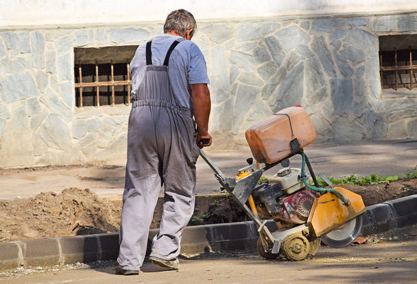 Bauarbeiter mit einer Asphaltsägemaschine - Foto, Bild
