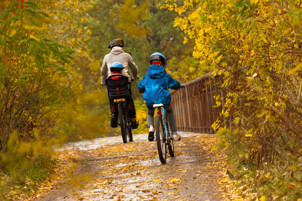 Active family cycling on bikes outdoors - Foto, Bild