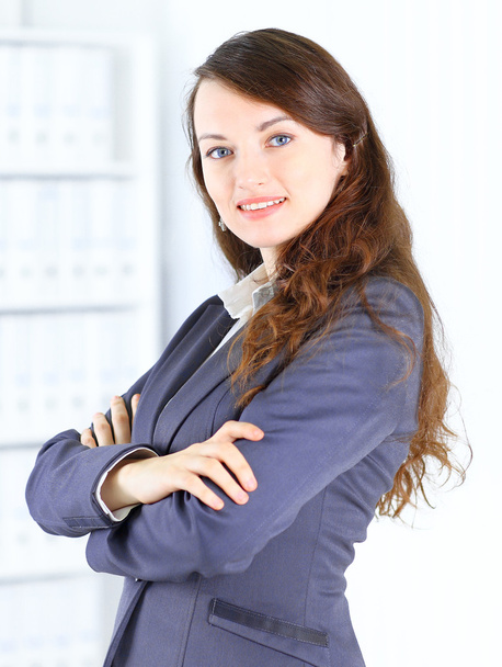 Portrait of a cute young business woman smiling, in an office environment - Foto, Bild
