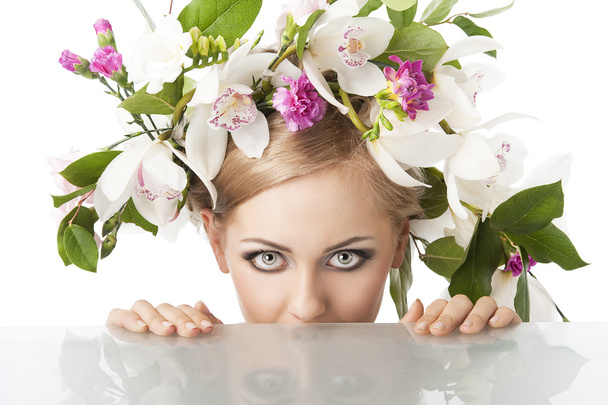 Pretty blond with flower crown on head, she is behind the table - Foto, afbeelding
