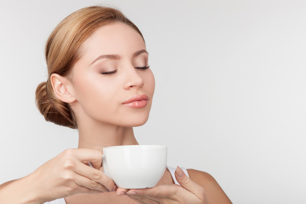 Cheerful healthy girl drinks tea with pleasure - Zdjęcie, obraz