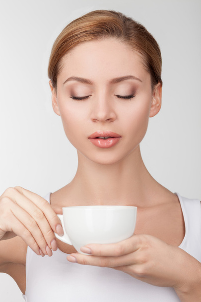 Beautiful young woman is enjoying hot coffee - Photo, Image