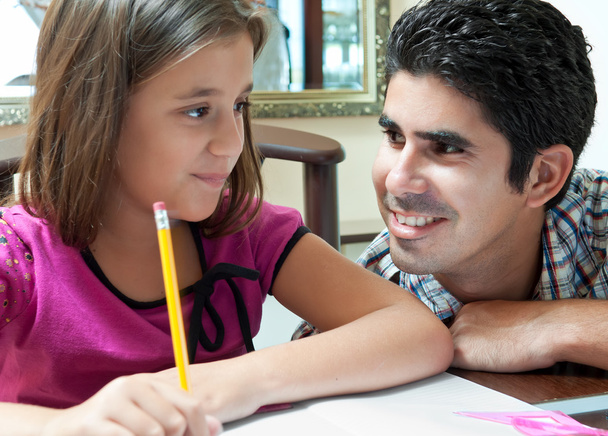 Young latin gather helping her daughter with homework - Photo, Image