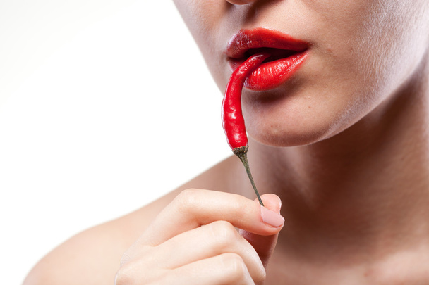 Young woman with chili pepper isolated on white - 写真・画像