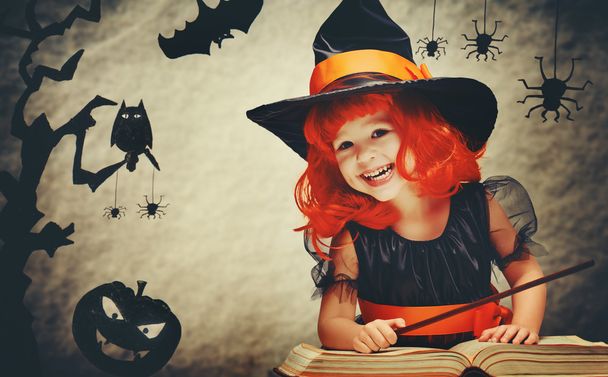 Halloween. vrolijke kleine heks met magische toverstaf en boek conjur - Foto, afbeelding