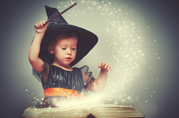 Halloween. alegre pequeña bruja con una varita mágica y brillante b
 - Foto, Imagen