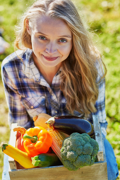 Young woman holding wooden crate with vegetables - Foto, Imagem