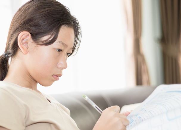 Asiatique fille écriture sur leçon livre
 - Photo, image