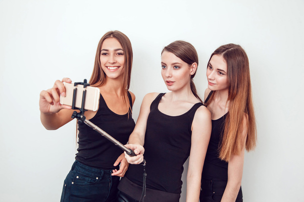 Beautiful young girls taking a photo with selfie stick - Zdjęcie, obraz