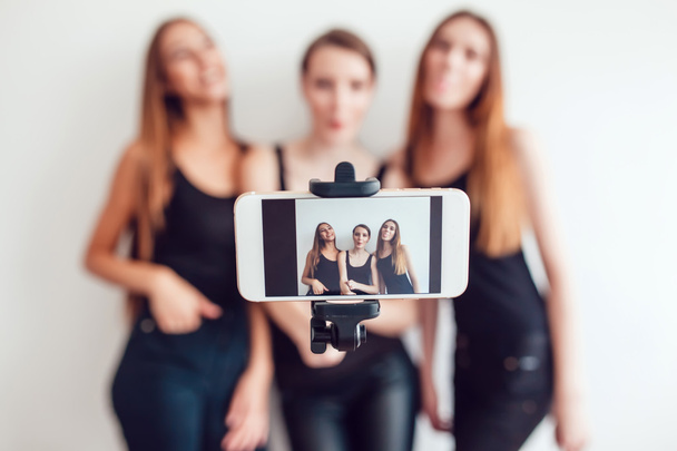 Beautiful young girls taking a photo with selfie stick - Zdjęcie, obraz