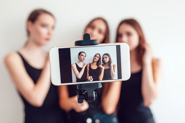 schöne junge Mädchen machen ein Foto mit Selfie-Stick - Foto, Bild