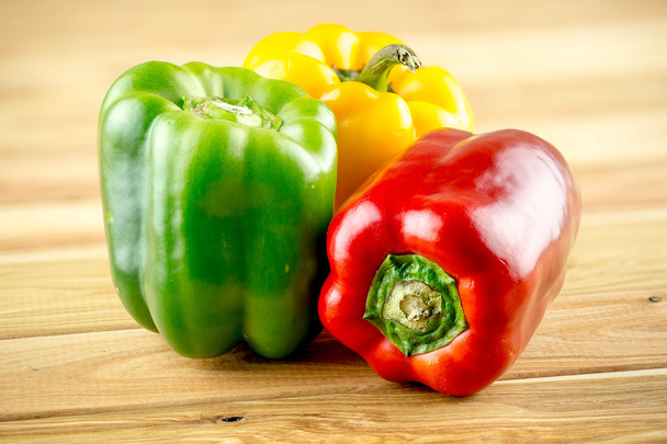 Red yellow and green peppers on wooden background - Photo, Image