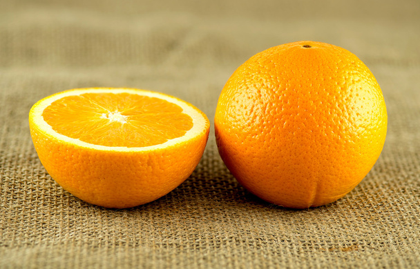 Perfecte oranje met doorsnede tegen rustieke jute Hessiaan - Foto, afbeelding