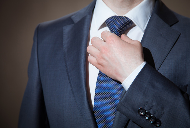 Επιχειρηματίας προσαρμόζει τη γραβάτα του - Φωτογραφία, εικόνα