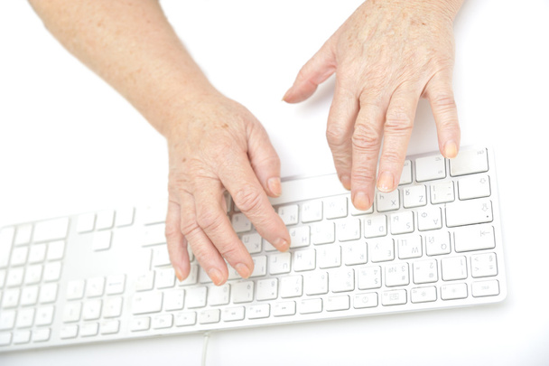 eller klavye, izole üzerinde beyaz, yakın çekim yazarak bir yaşlı kadın. - Fotoğraf, Görsel