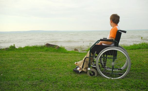 άνθρωπος σε αναπηρική καρέκλα σε εξωτερικούς χώρους απολαμβάνοντας παραλία - Φωτογραφία, εικόνα