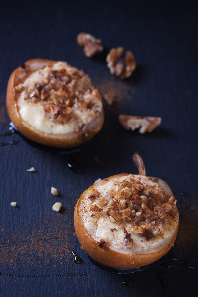 Baked pears with cottage cheese, honey and walnuts on dark background - Foto, afbeelding