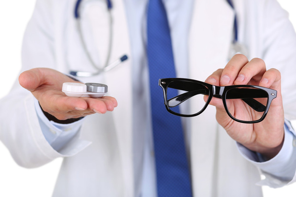 Мужские руки врача, дающие черные очки
 - Фото, изображение