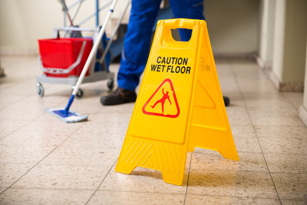 Worker Mopping Floor With Wet Floor Caution Sign - Fotoğraf, Görsel
