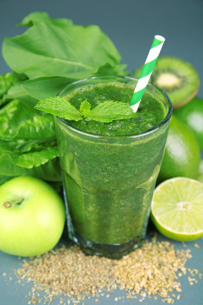 Green healthy juice with fruits and herbs on table close up - Photo, image