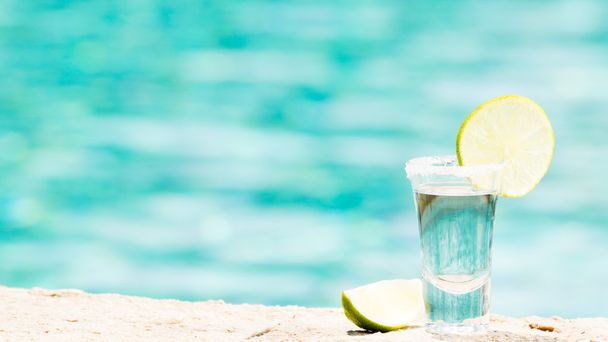 Tequila Shot mit Limette auf blauem Hintergrund - Foto, Bild