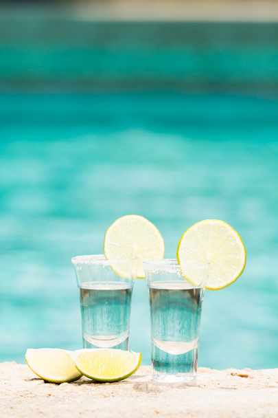 Tequila colpi con calce su sfondo blu
 - Foto, immagini
